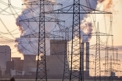 Germany, north rhine westphalia, niederaussem, electricity pylons and lignite power station at sunset