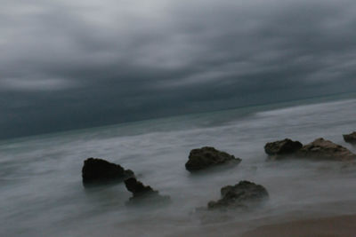 Scenic view of sea against storm clouds