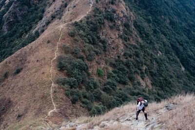 High angle view of hiker on steep field