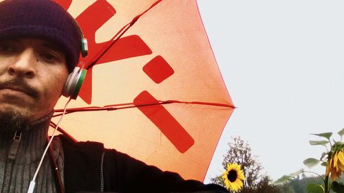 Red umbrella flying against sky