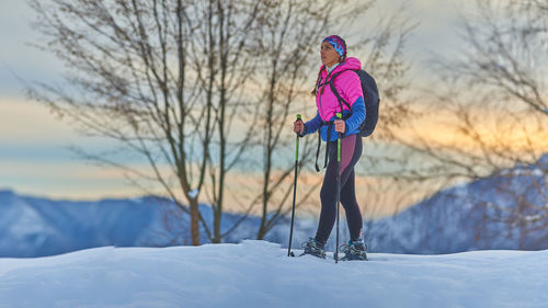 Full length of woman standing on snow covered landscape