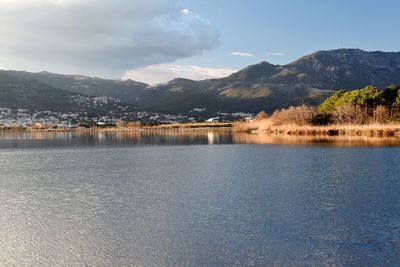 Scenic view of lake by mountains against sky