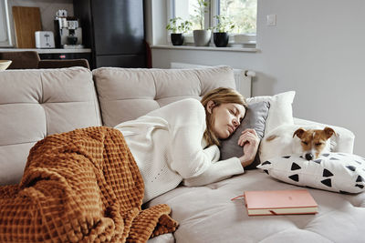 Woman sleep with dog on sofa