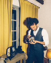 Full length of man photographing with polaroid camera