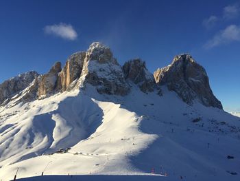 Scenic view of snow covered mountains against blue sky