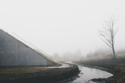 Scenic view of lake against sky during foggy weather