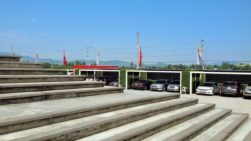 Steps by cars in parking lots against clear sky