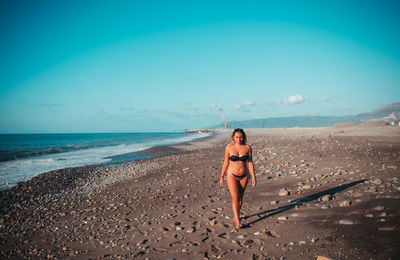 Full length of woman on beach against sky