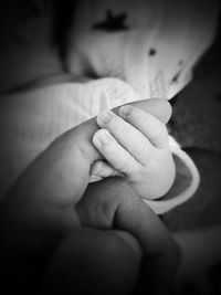 Close-up of father holding baby hand
