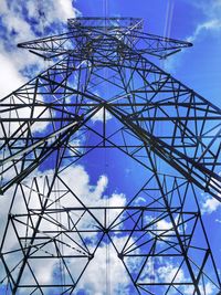 Low angle view of electricity pylon against cloudy sky