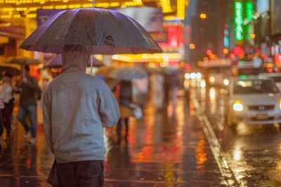 People on times square sidewalk in the rain
