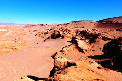Scenic view of desert against clear blue sky