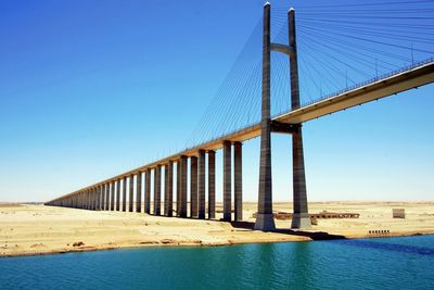 Low angle view of suez canal bridge against blue sky