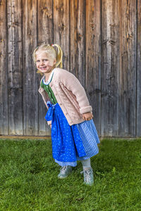 Portrait of happy girl standing on field