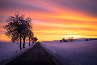 Scenic view of snow covered land during sunset