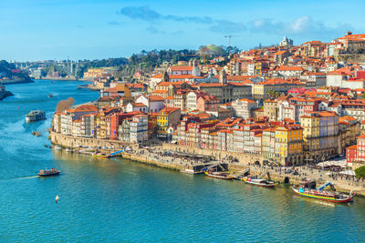 High angle view of city by sea against sky