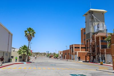 Street amidst buildings against clear blue sky