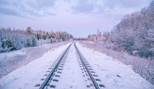 View of snow covered railroad tracks against sky