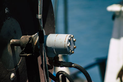 Close-up of pipes on sea against blue sky