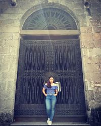 Portrait of woman standing against building