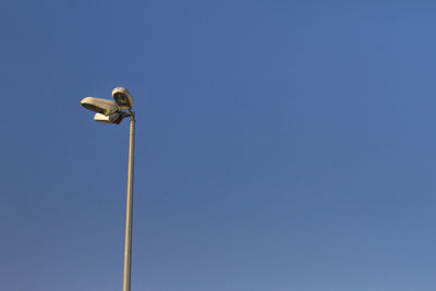 Low angle view of floodlight against clear blue sky