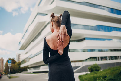 Woman standing by building in city