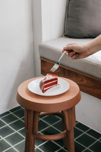 Midsection of person holding ice cream on table