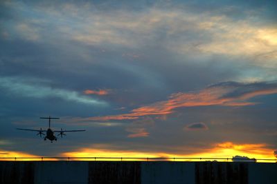 Silhouette airplane against sky during sunset