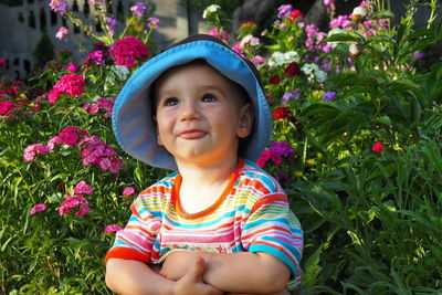 Portrait of cute baby girl against pink flowering plants