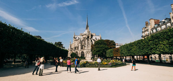 Group of people in front of building against sky