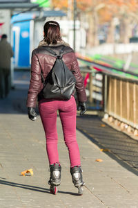 Rear view of woman walking on footpath