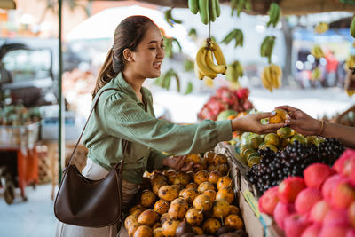 Portrait of woman holding fruits at market