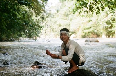 Side view of young man in river