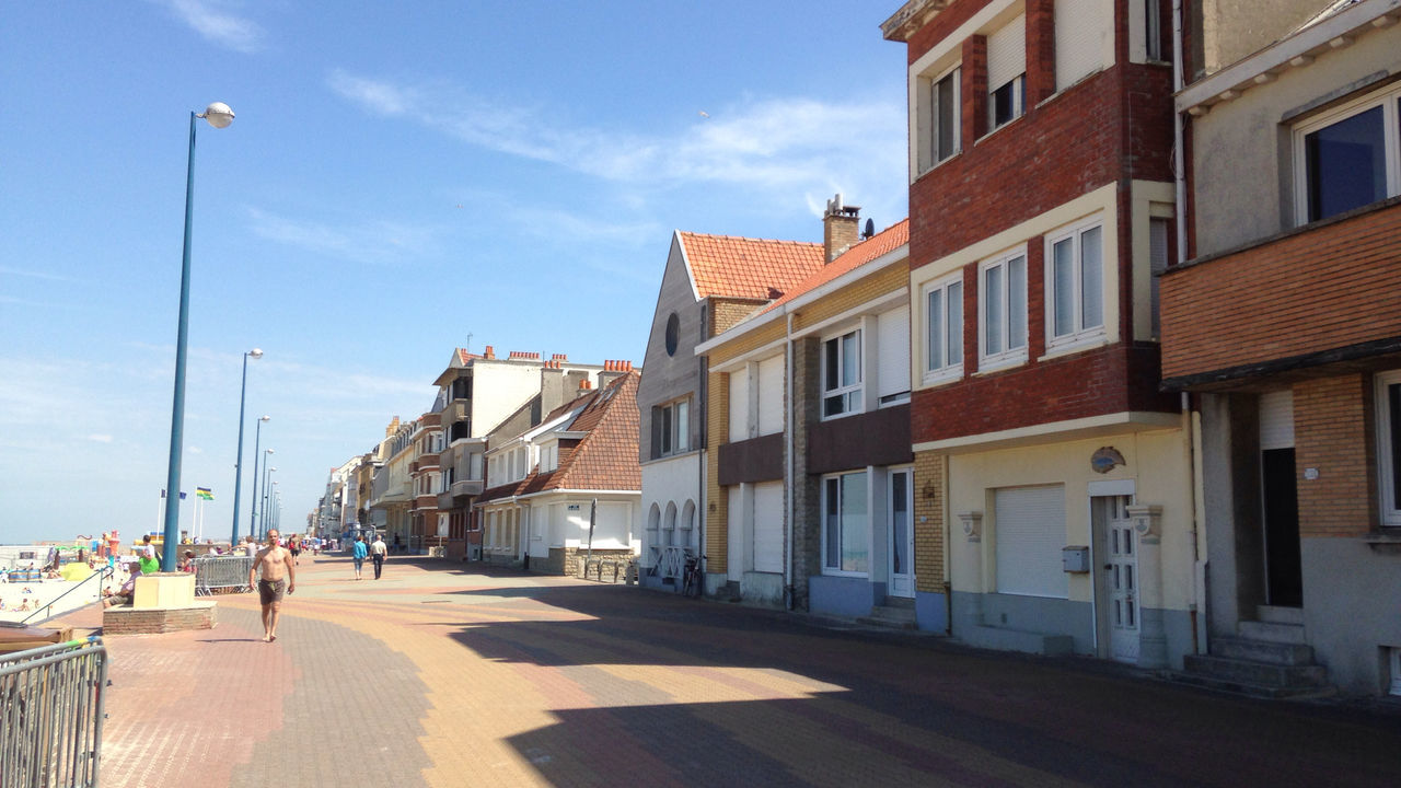 building exterior, architecture, built structure, sky, the way forward, street, city, street light, walking, sunlight, cobblestone, residential building, incidental people, men, residential structure, shadow, city life, person, lifestyles