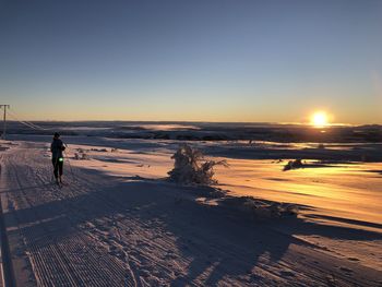 Scenic view of winter landscape against sky during sunset