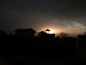 Silhouette house against sky during sunset