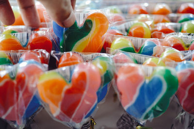 Cropped hand holding plastic with candy