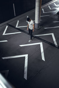 High angle view of man crossing sign on road in city