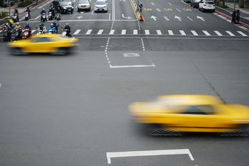 Blurred motion of taxis moving on road in city