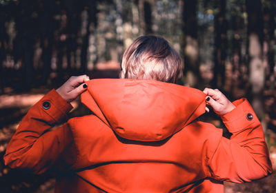 Rear view of woman sitting in forest