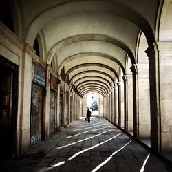 Rear view of person walking in corridor of building