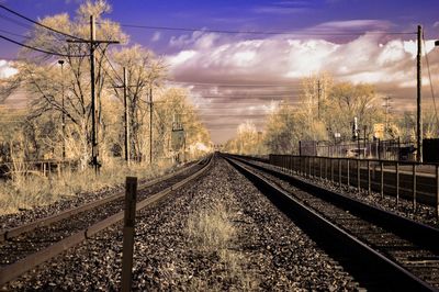 Railroad tracks by trees against sky