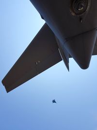 Low angle view of airplane against clear blue sky