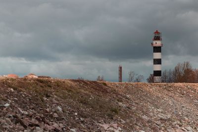 Lighthouse by sea against sky