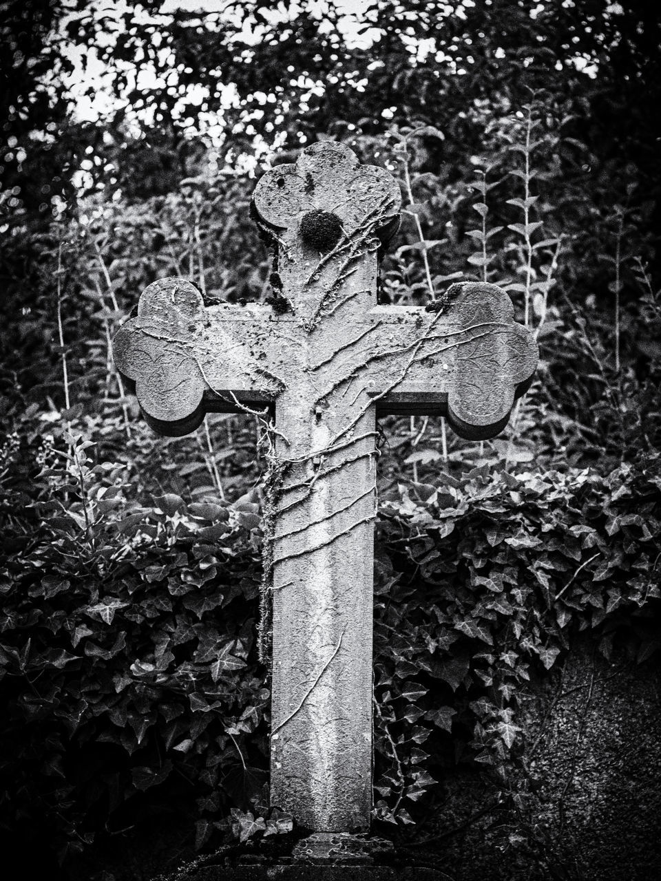 CLOSE-UP OF CROSS SCULPTURE IN CEMETERY