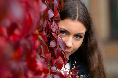 Portrait of beautiful woman with red plant