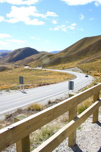 Road by mountains against sky