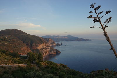 Scenic view of sea and mountains against sky