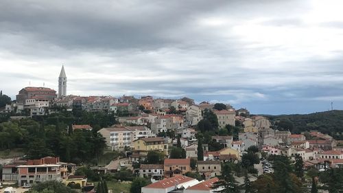 View of buildings in city against cloudy sky