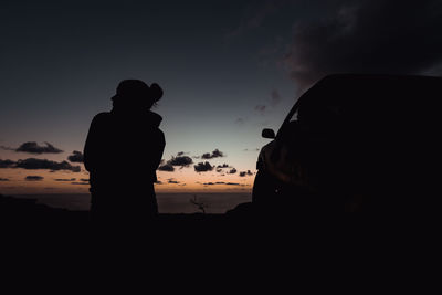 Silhouette girl standing against sky during sunset